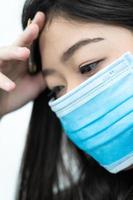 Close up woman with headache wearing mask for protect Covid-19 photo