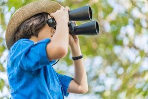 mujer de cerca use sombrero y sostenga binocular en el campo de hierba foto