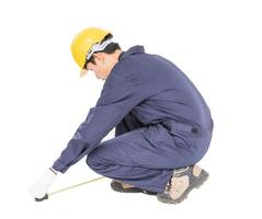 Young worker in unifrom with tape measure isolated on white photo