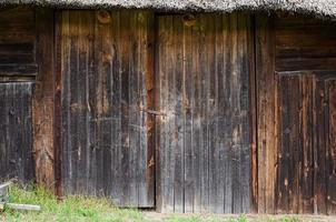 old weathered door in the wooden wall of an ancient hut photo