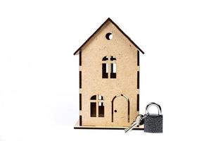 símbolo de la casa con llave de metal sobre fondo blanco. bienes raíces, concepto de seguro, hipoteca, compra venta de casa, concepto de agente inmobiliario foto
