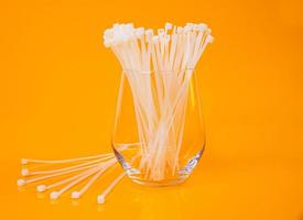 nylon cable ties in glass in jar in bucket on orange background photo