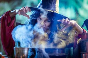 joven bruja está cocinando con magia foto
