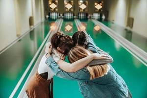 tres jugadoras de bolos divirtiéndose y celebrando la victoria foto