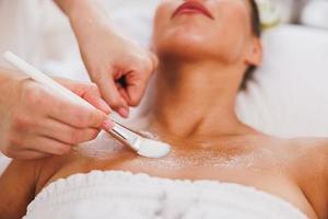 mujer recibiendo un tratamiento de máscara facial en el salón de belleza foto