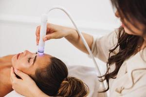 Beauty Therapist Performing Hydrafacial Procedure On Woman photo
