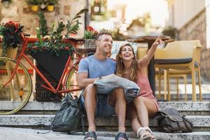 Tourist Couple Sightseeing Mediterranean City With Map On A Summer Vacation photo