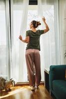 Woman Enjoying View Through The Window In The Morning Sunshine photo