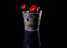 aluminum ice bucket laid in wait for use. stainless multi-colored bucket with red apples photo