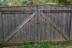 old weathered door in the wooden wall of an ancient hut photo