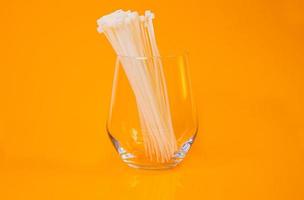 nylon cable ties in glass in jar in bucket on orange background photo