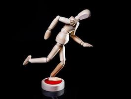 Image of wooden manikin on black background poses different posing photo