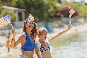 Two Female Friends With American National Flag Having Fun At Summer Vacation photo