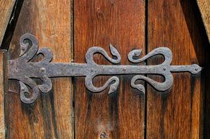 Old wooden gate closed on rusty padlock, texture photo