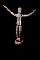 Image of wooden manikin on black background poses different posing photo