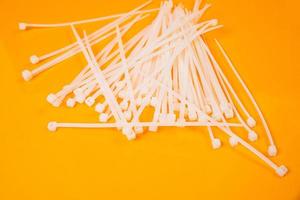 nylon cable ties in glass in jar in bucket on orange background photo