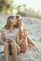 Two Female Friends Having Fun While Enjoying A Summer Vacation At The Beach photo