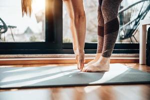 mujer practicando ejercicios de yoga de estiramiento en casa foto