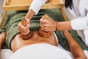 masaje de maderoterapia con copa de madera en un centro de spa foto