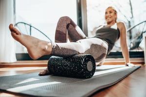 Woman Doing Workout With Foam Roller At Home photo