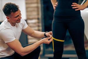 entrenador midiendo el volumen de la pierna de la mujer foto