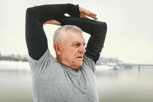 Senior Man Stretching By The River photo