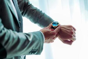 man putting clock on hand,groom getting ready in the morning photo