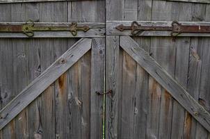 old weathered door in the wooden wall of an ancient hut photo