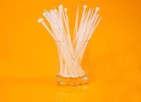 nylon cable ties in glass in jar in bucket on orange background photo