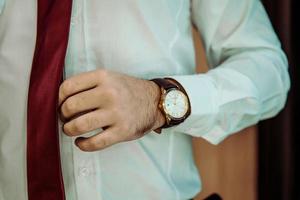 hombre poniendo reloj a mano, novio preparándose por la mañana foto