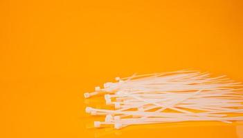 nylon cable ties in glass in jar in bucket on orange background photo