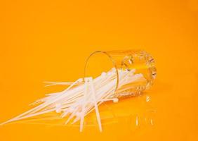 nylon cable ties in glass in jar in bucket on orange background photo