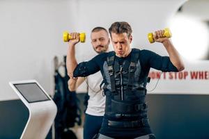 hombre haciendo ejercicio ems en el gimnasio foto