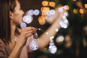 Young Woman Playing With Lights Bulbs On New Year's Eve