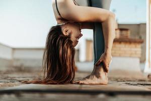 Woman Doing Yoga Outdoors On A Rooftop Terrace photo