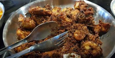 Ayam goreng rempah or traditional Javanese fried chicken, cooked on frying pan photo