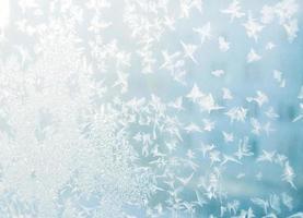 Beautiful rime close-up photo. Frost patterns on frozen window as a symbol of Christmas wonder. photo