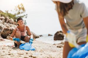 Mother And Daughter Collecting Trash On The Beach photo