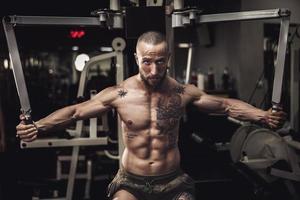 Man Doing Training On Machine For His Chest Muscle At The Gym photo