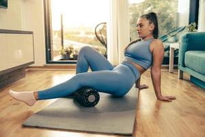 Woman Doing Workout With Foam Roller At Home photo