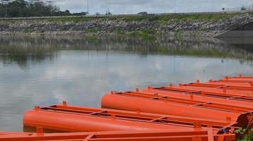 Stock photo of the orange iron tank drum barrier area on the edge of the reservoir