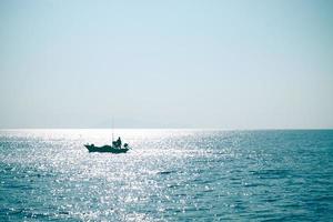 Fisherman in the blue sea photo