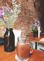 deliciosa bebida vegetariana servida en la mesa con flores para una bebida de verano con efecto de filtro retro foto