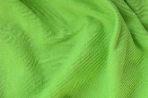 The texture of the fabric is bright green. Material for making shirts and blouses photo
