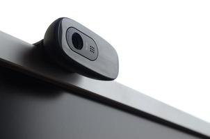 A modern web camera is installed on the body of a flat screen monitor. Device for video communication and recording of high quality video photo