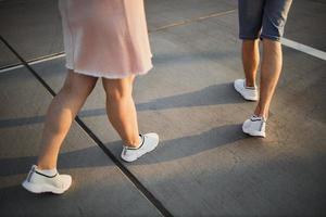 legs of a man and a woman at sunset photo