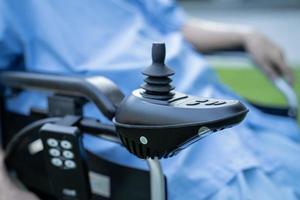 Asian senior or elderly old lady woman patient on electric wheelchair with remote control at nursing hospital ward, healthy strong medical concept photo