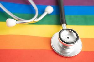 Black stethoscope on rainbow flag background, symbol of LGBT pride month  celebrate annual in June social, symbol of gay, lesbian, bisexual, transgender, human rights and peace. photo