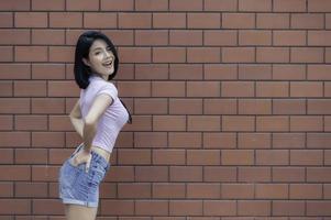 Portrait of hipster girl  on brick wall background,Beautiful asian woman pose for take a photo