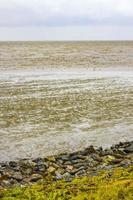 Beautiful coastal dike landscape panorama water stones fields forest Germany. photo